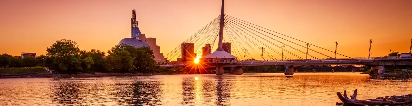 Winnipeg skyline at sunset over the Red River — Esplanade Riel bridge and Canadian Museum for Human Rights